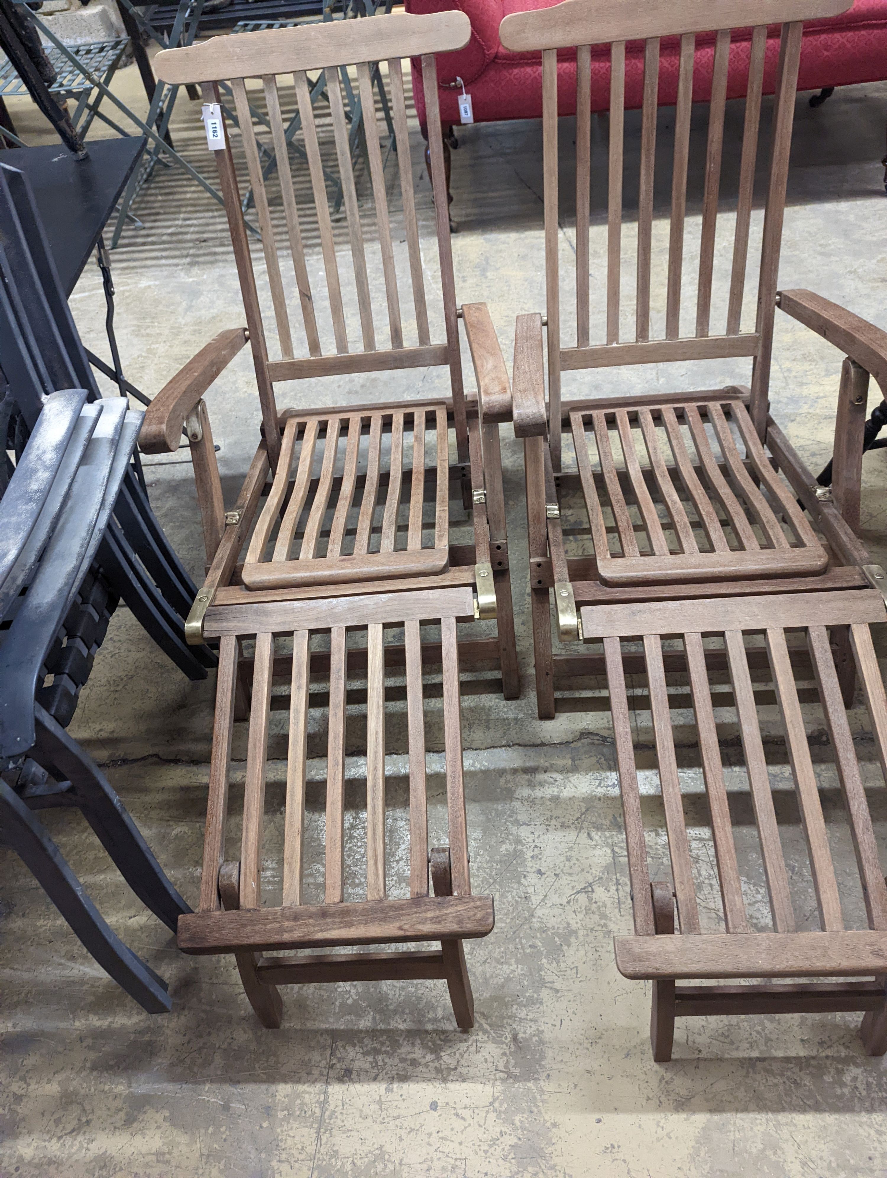 A pair of brass mounted teak garden steamer chairs, length 140cm, depth 58cm